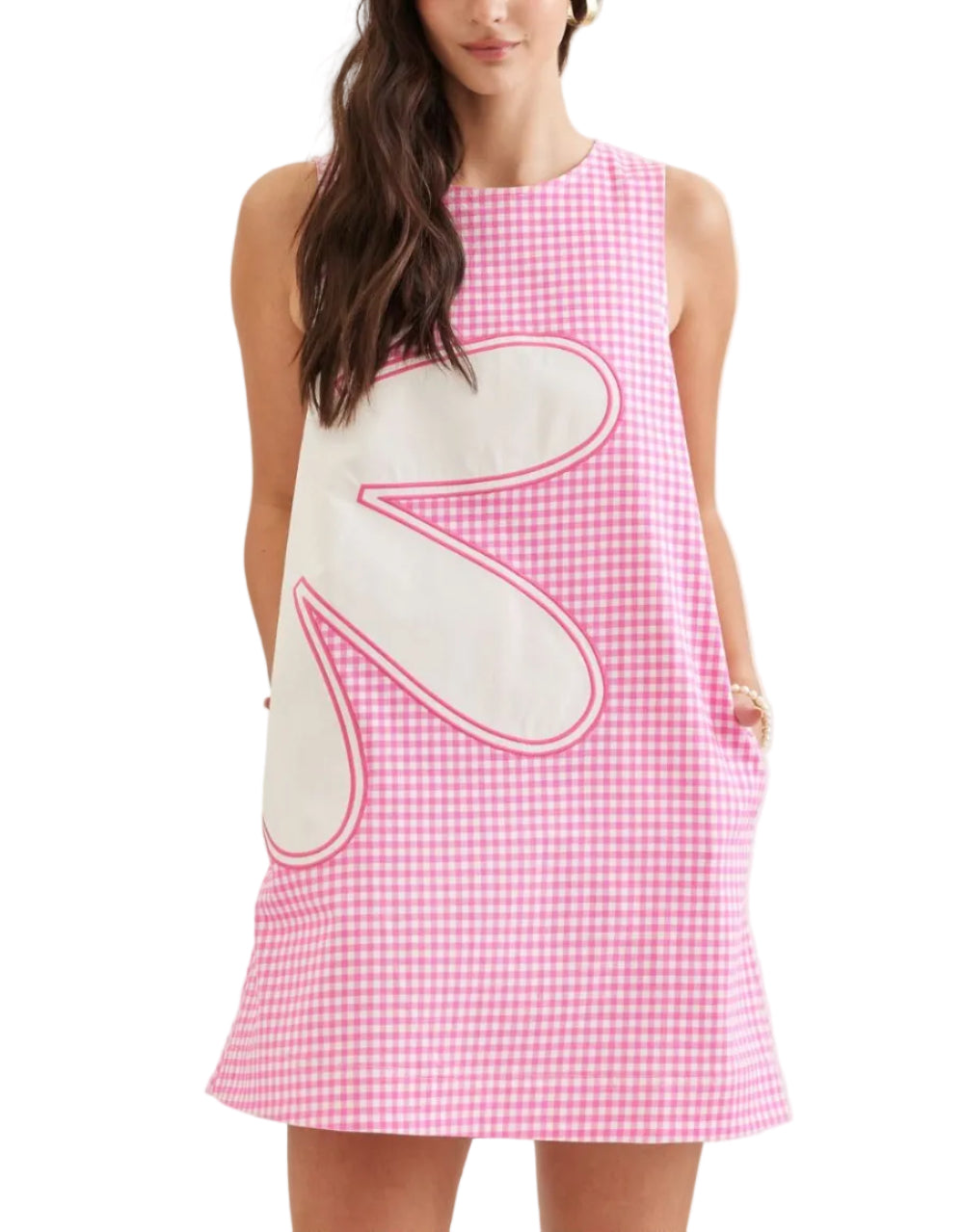 Woman wearing a pink checkered dress with a large white bow on a plain background