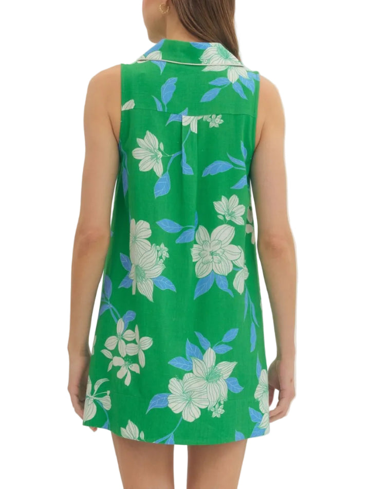 Floral sleeveless mini dress featuring contrast binding detail at collar and front. V-neck. Front patch pockets. Back yoke pleat detail. Lined. Woven. Non-sheer. Lightweight.