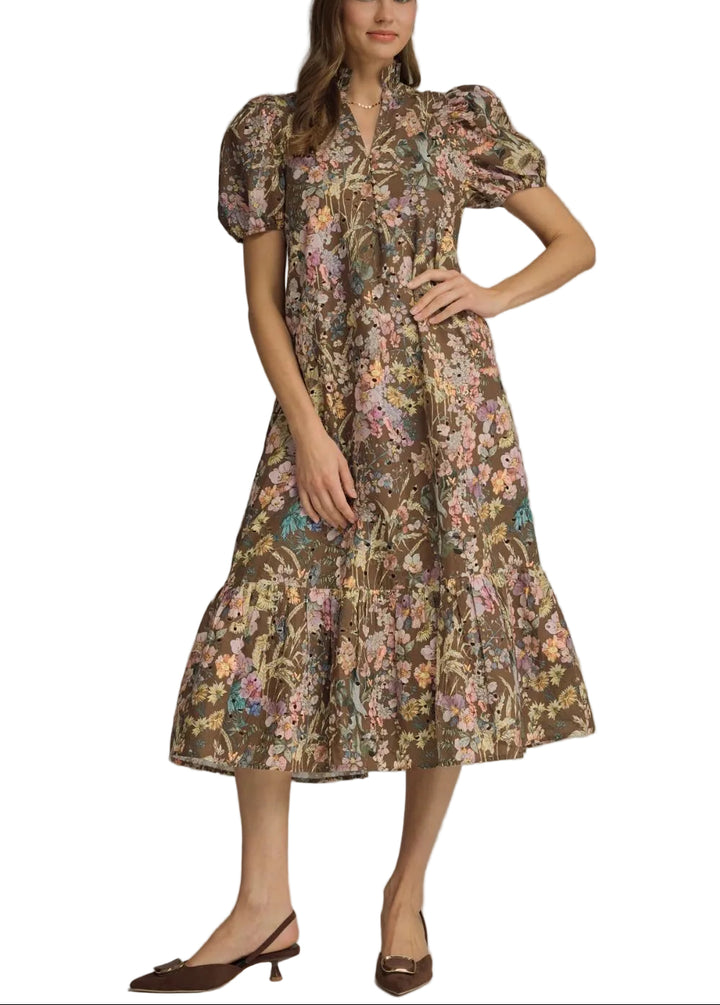 Floral eyelet short puff sleeve midi dress featuring ruffled neck band collar V-neck. Button closure at front. Side pockets. Lined. Woven. Non-sheer. Lightweight.