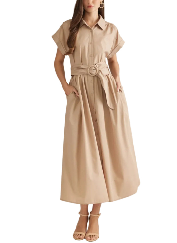 A woman modeling a beige short-sleeve midi shirt dress with a matching waist tie belt and large round buckle, styled with neutral heeled sandals against a plain light beige studio background.