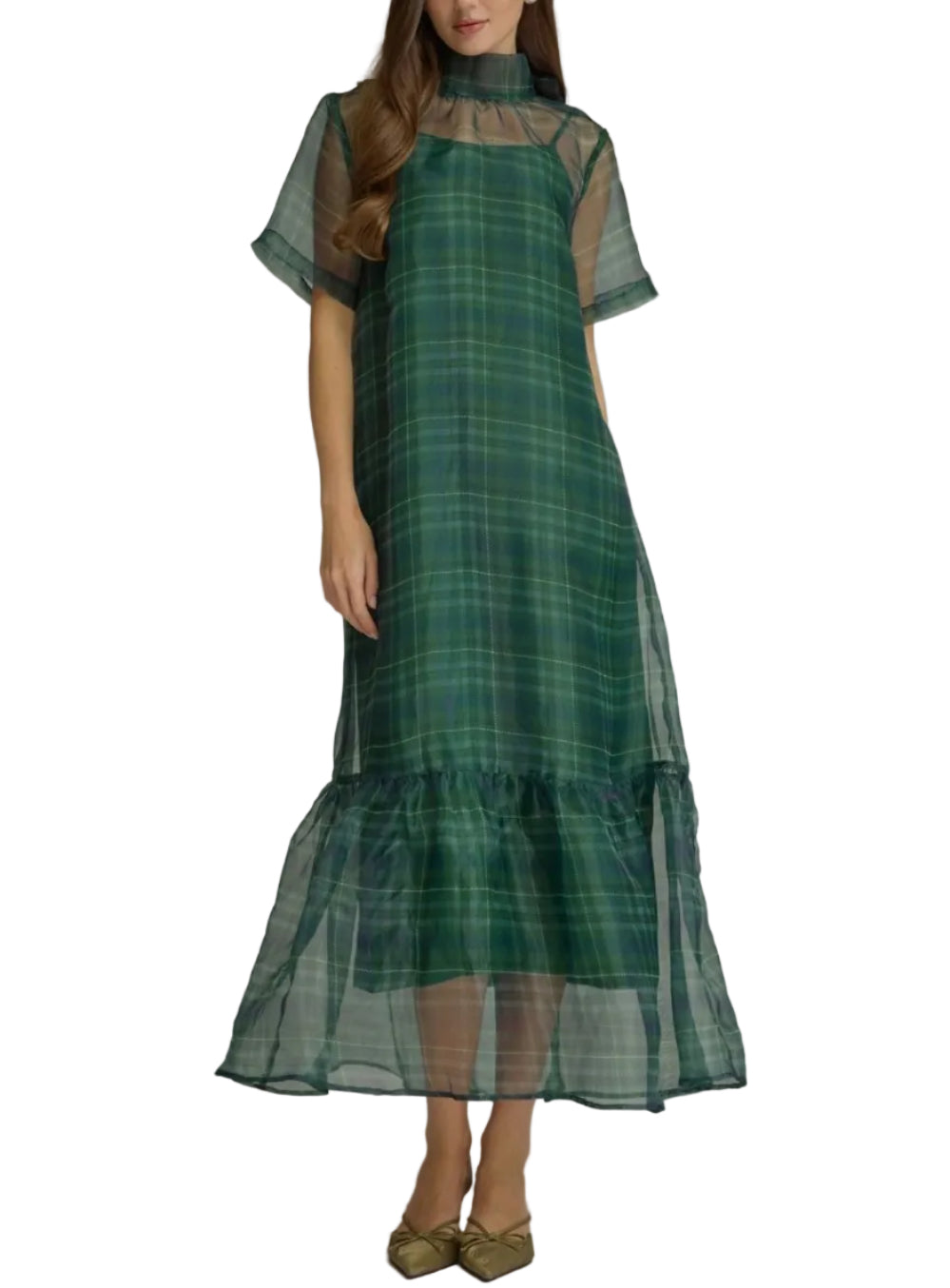 A woman models a green plaid midi dress with sheer short sleeves, a high mock neck, and a tiered ruffled hem, set against a plain gray studio background.