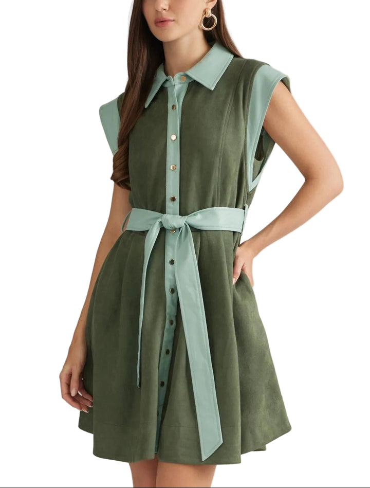 Solid sleeveless mini dress with a shirt collar and snap button closure at front. Contrast faux leather trim detail at collar, armholes, front, and belt. Self-tie belt at waist. Side pockets. Unlined. Woven. Non-sheer. Lightweight.