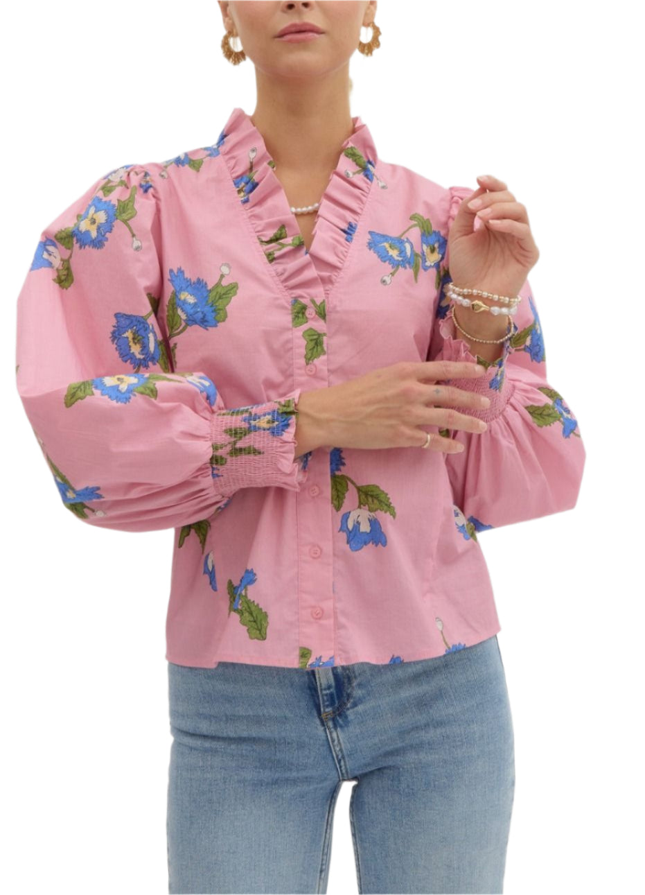 Printed button front smocked cuff long sleeve top featuring v-neck with accented with voluminous ruffle. Unlined. Woven. Non-sheer. Lightweight.