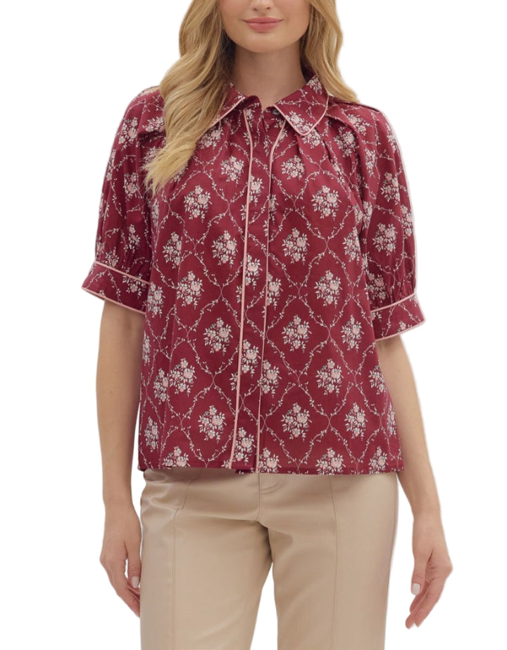 Floral print pleated raglan puff sleeve top featuring piped detailing throughout and a classic shirt collar. Button-front closure. Unlined. Woven. Non-sheer. Lightweight.
