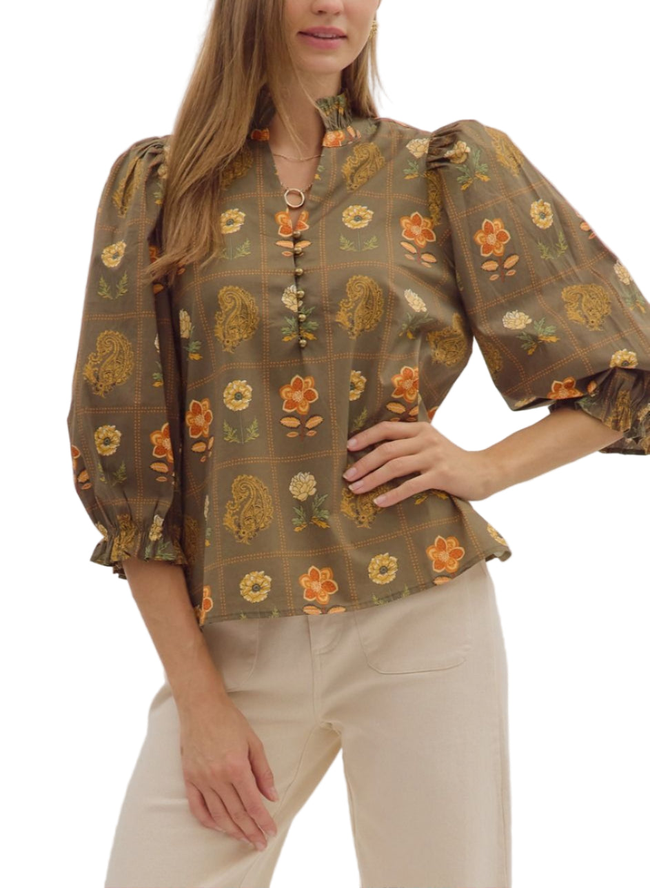 Floral and paisley print 3/4 puff sleeve top featuring ruffled high neck and loop button closure at front. Elasticated sleeve openings with ruffle trim. Unlined. Woven. Non-sheer. Lightweight.
