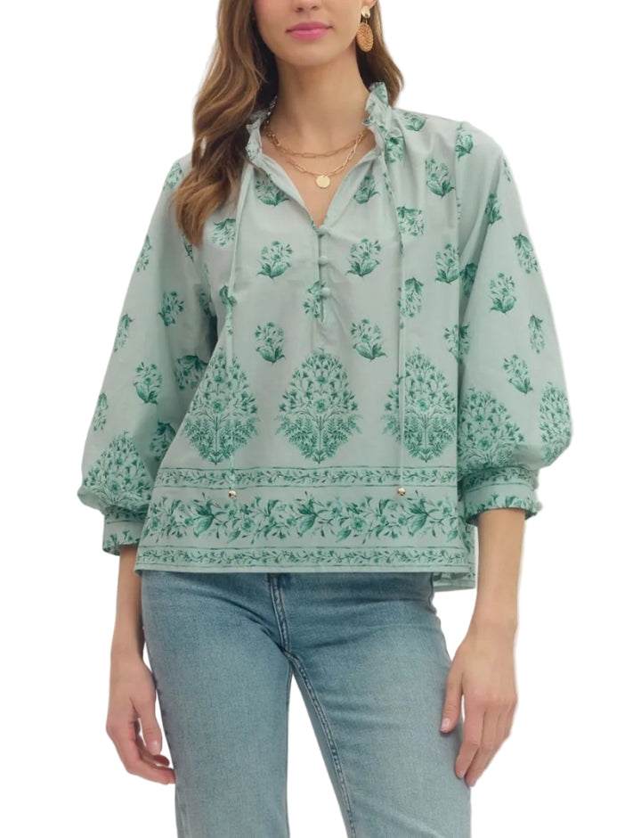 Botanical print balloon 3/4 sleeve top featuring ruffle split neckline with button placket. Button closure at cuff. Unlined. Woven. Non-sheer. Lightweight.
