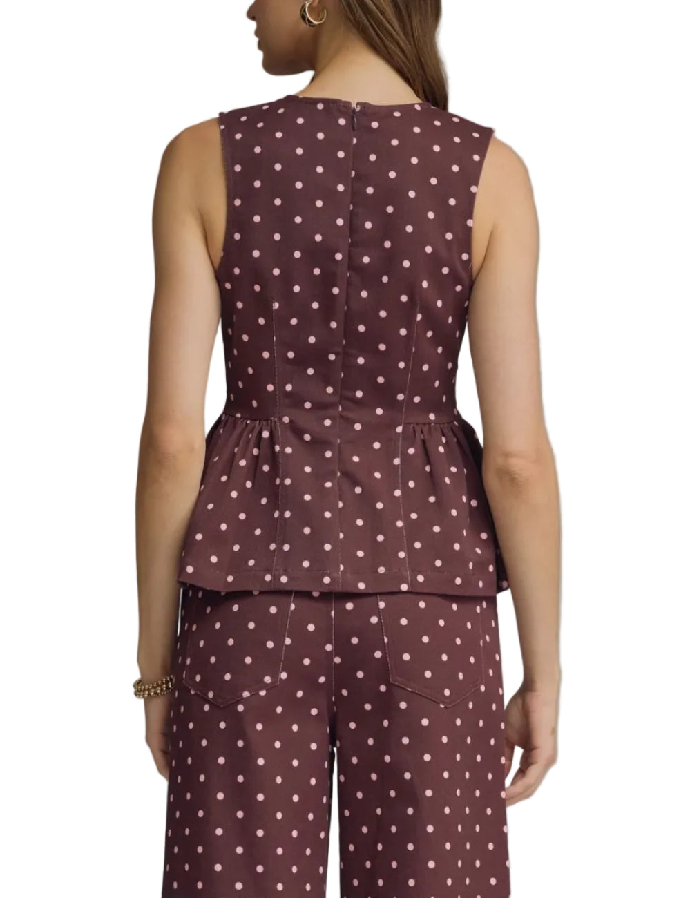 Polka dot sleeveless top featuring peplum hem detail. Back zipper closure. Unlined. Woven. Non-sheer. Lightweight
