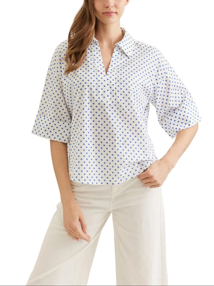 Polka dot short sleeve top featuring cuff button detail. Collar neckline. Split V-neck. Back tab detail. Unlined. Woven. Non-sheer. Lightweight.