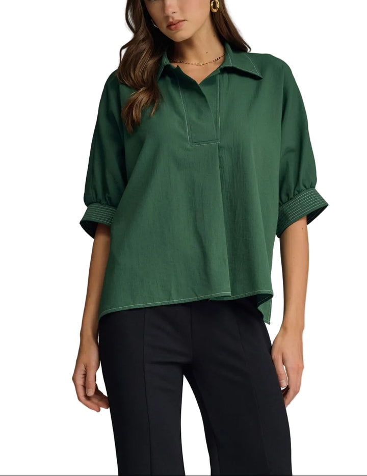 Solid short sleeve top featuring split V-neck collar. Contrast stitch detail at collar and cuffs. Side slits. Unlined. Woven. Non-sheer. Lightweight.