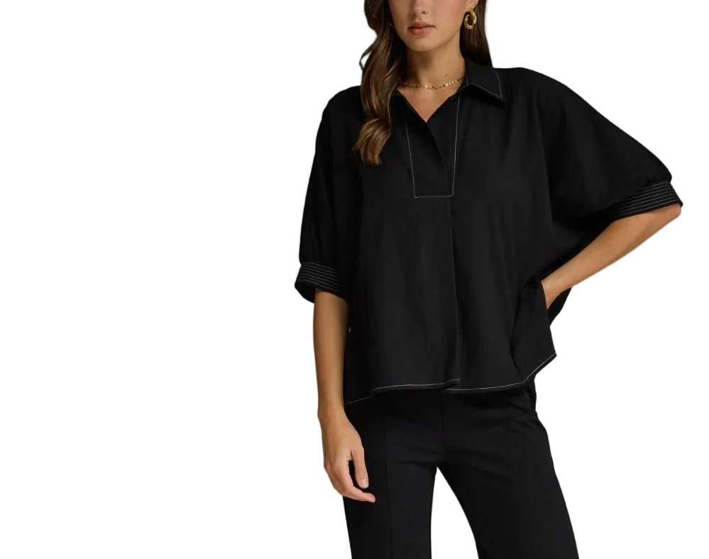 Solid short sleeve top featuring split V-neck collar. Contrast stitch detail at collar and cuffs. Side slits. Unlined. Woven. Non-sheer. Lightweight.