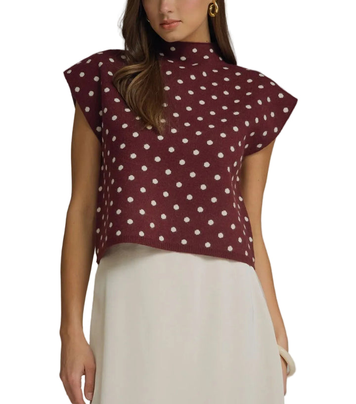 Polka dot mock neck sleeveless top featuring cap sleeve detail. Unlined. Woven. Non-sheer. Lightweight.