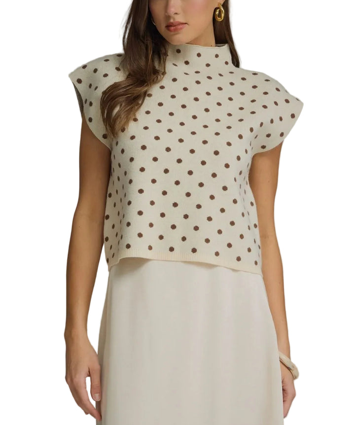 Polka dot mock neck sleeveless top featuring cap sleeve detail. Unlined. Woven. Non-sheer. Lightweight.
