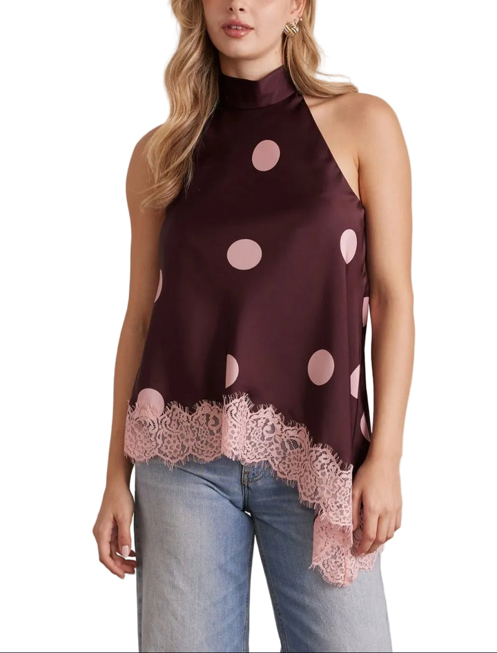 The Beau Polka Dot Halter Top combines playful style with elegant details. Classic polka dots create a timeless look, while delicate lace trim adds a touch of sophistication. The asymmetrical hem brings modern movement and visual interest to this versatile piece. Perfect for casual outings or dressed up for special occasions, this halter top offers a flattering silhouette with contemporary flair.