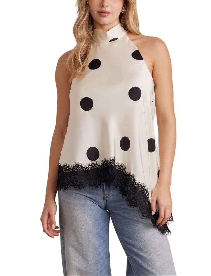 The Beau Polka Dot Halter Top combines playful style with elegant details. Classic polka dots create a timeless look, while delicate lace trim adds a touch of sophistication. The asymmetrical hem brings modern movement and visual interest to this versatile piece. Perfect for casual outings or dressed up for special occasions, this halter top offers a flattering silhouette with contemporary flair.