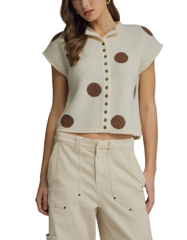 Polka dot collared short sleeve sweater knit top featuring button closure at front. Rolled sleeve openings. Unlined. Knit. Non-sheer. Lightweight.
