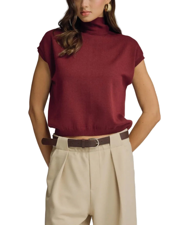 Solid mock neck cap sleeve knit top featuring scarf tie detail. Button closure at back neck. Unlined. Knit. Non-sheer. Lightweight.
