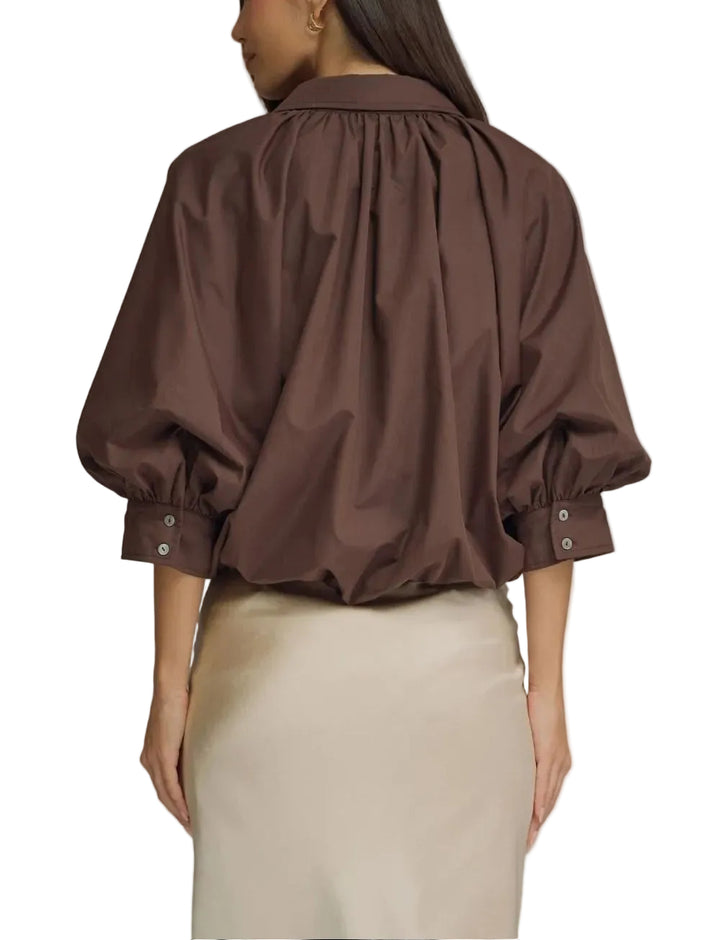 Solid ¾ puff sleeve top featuring gathered detail at front and back yoke. Button closure at front. Button at cuff. Elasticated hem. Lined. Woven. Non-sheer. Lightweight.