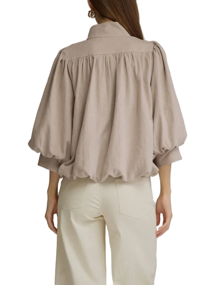 Solid ¾ balloon sleeve top with a stand collar and partial button closure at front. Lined. Woven. Non-sheer. Lightweight.
