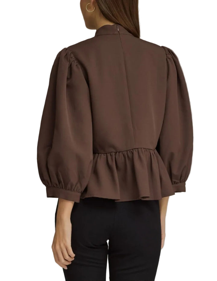 Solid long puff sleeve top with a high neckline. Frog button closure at front. Back zipper. Peplum hem. Unlined. Woven. Non-sheer. Lightweight.
