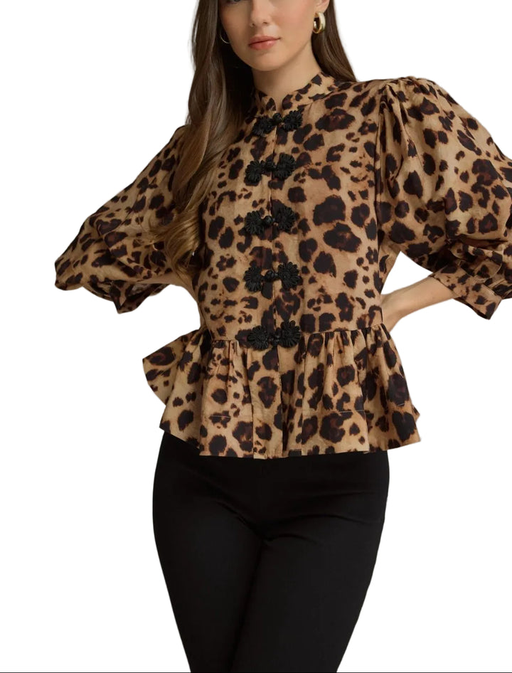 Animal print 3/4 puff sleeve top with a high neckline. Frog button closure at front. Back zipper. Peplum hem. Unlined. Woven. Non-sheer. Lightweight.