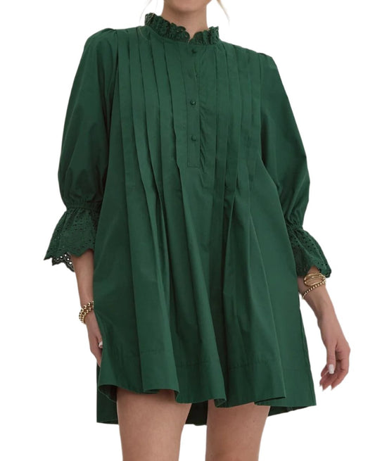 Solid round neck 3/4 sleeve pleat mini dress featuring eyelet detail at cuff and neckline. Button closure at front. Elastic at cuff. Pocket at sides. Lined. Woven. Non-sheer. Lightweight.