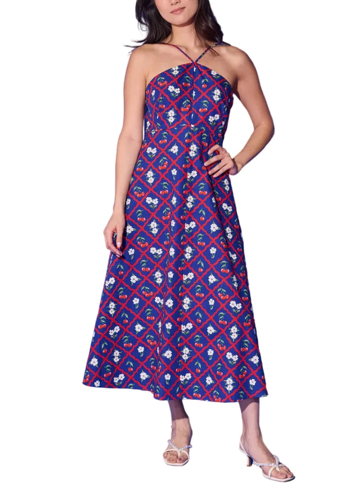 The Karin Dress is the navy cherry lattice print at its most elegant. A sleek halter neckline with delicate cross-back straps frames the shoulders beautifully, while the fitted bodice flows into a full, sweeping midi skirt that moves with effortless grace. Bold red trellis, bright cherries, and white florals pop against the deep navy ground for a look that&