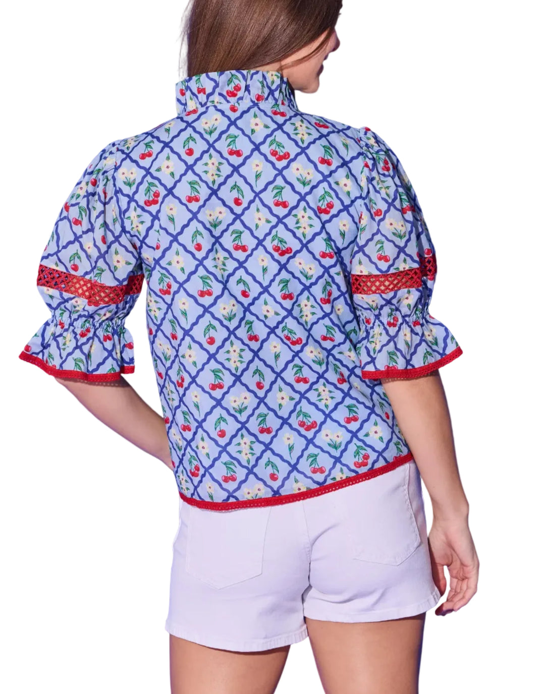 The Lottie Top brings a fun and flirty energy to the beloved cherry lattice print. Voluminous puff sleeves gather into ruffled cuffs accented with red crochet trim — the same playful detail that frames the split V-neckline and hem. The relaxed, easy-to-wear silhouette pairs effortlessly with white shorts or denim for a summer look that&