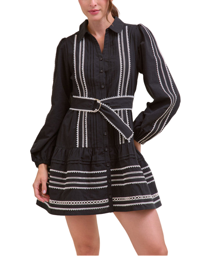 Compliments will be rolling in when you’ve got on this lace trim belted mini dress! Perfect for those autumn days, this woven dress features a collared neckline and long puff sleeves with elastic cuffs. A pin tuck and contrast lace trim bodice boasts a functional button placket before continuing to a drop waist seam with tiered pin tuck and contrast lace trim that ends at a mini hem. Lace trimmed belt cinches the waist.
