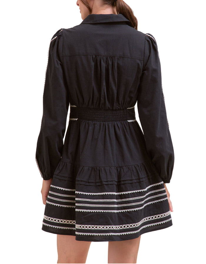 Compliments will be rolling in when you’ve got on this lace trim belted mini dress! Perfect for those autumn days, this woven dress features a collared neckline and long puff sleeves with elastic cuffs. A pin tuck and contrast lace trim bodice boasts a functional button placket before continuing to a drop waist seam with tiered pin tuck and contrast lace trim that ends at a mini hem. Lace trimmed belt cinches the waist.
