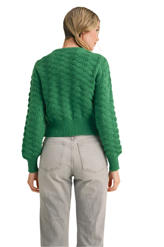 textured sweater knit that shapes a button front design with knit rosettes and a relaxed fit framed by long sleeves with ribbed cuffs.