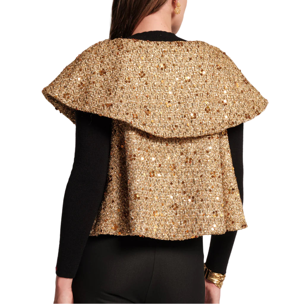 Elevate your holiday look with the Peyton Swing Jacket, a luxurious topper designed to drape effortlessly over your favorite look. Crafted with a shimmering metallic tweed and swaying silhouette, it features cape styling, with open arm holes for ease of movement. The double-layer collar and a captivating mix of wool and sequins adds a touch of subtle glamour. Top off your go-to festive outfit to add a touch of warmth and sparkle to any special night.