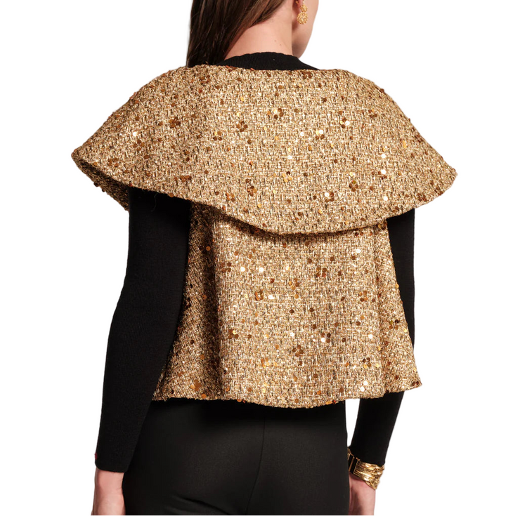 Elevate your holiday look with the Peyton Swing Jacket, a luxurious topper designed to drape effortlessly over your favorite look. Crafted with a shimmering metallic tweed and swaying silhouette, it features cape styling, with open arm holes for ease of movement. The double-layer collar and a captivating mix of wool and sequins adds a touch of subtle glamour. Top off your go-to festive outfit to add a touch of warmth and sparkle to any special night.