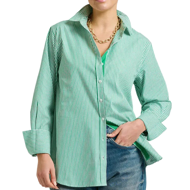 Woman wearing a green checkered shirt and blue jeans on a light gray background