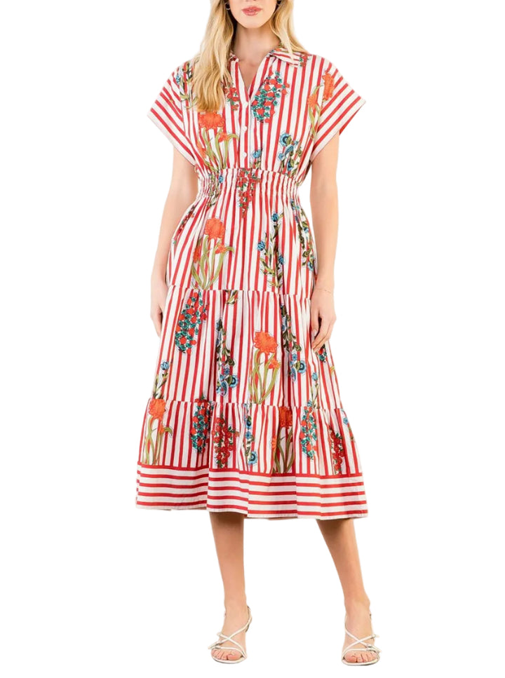 Woman wearing a red and white striped dress with floral patterns on a plain background