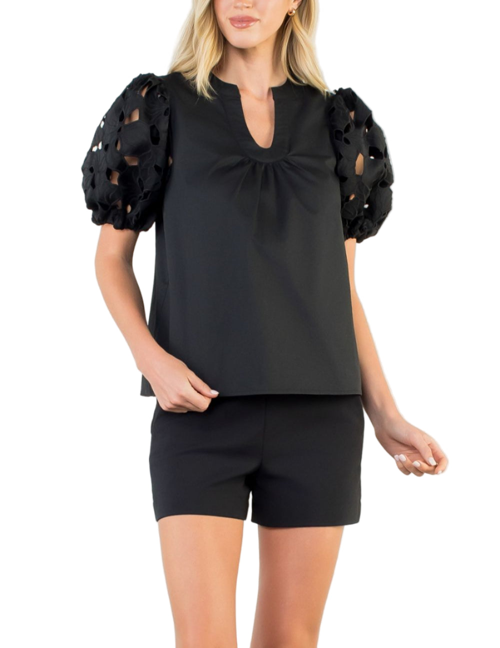 Woman wearing a black top with puff sleeves on a white background