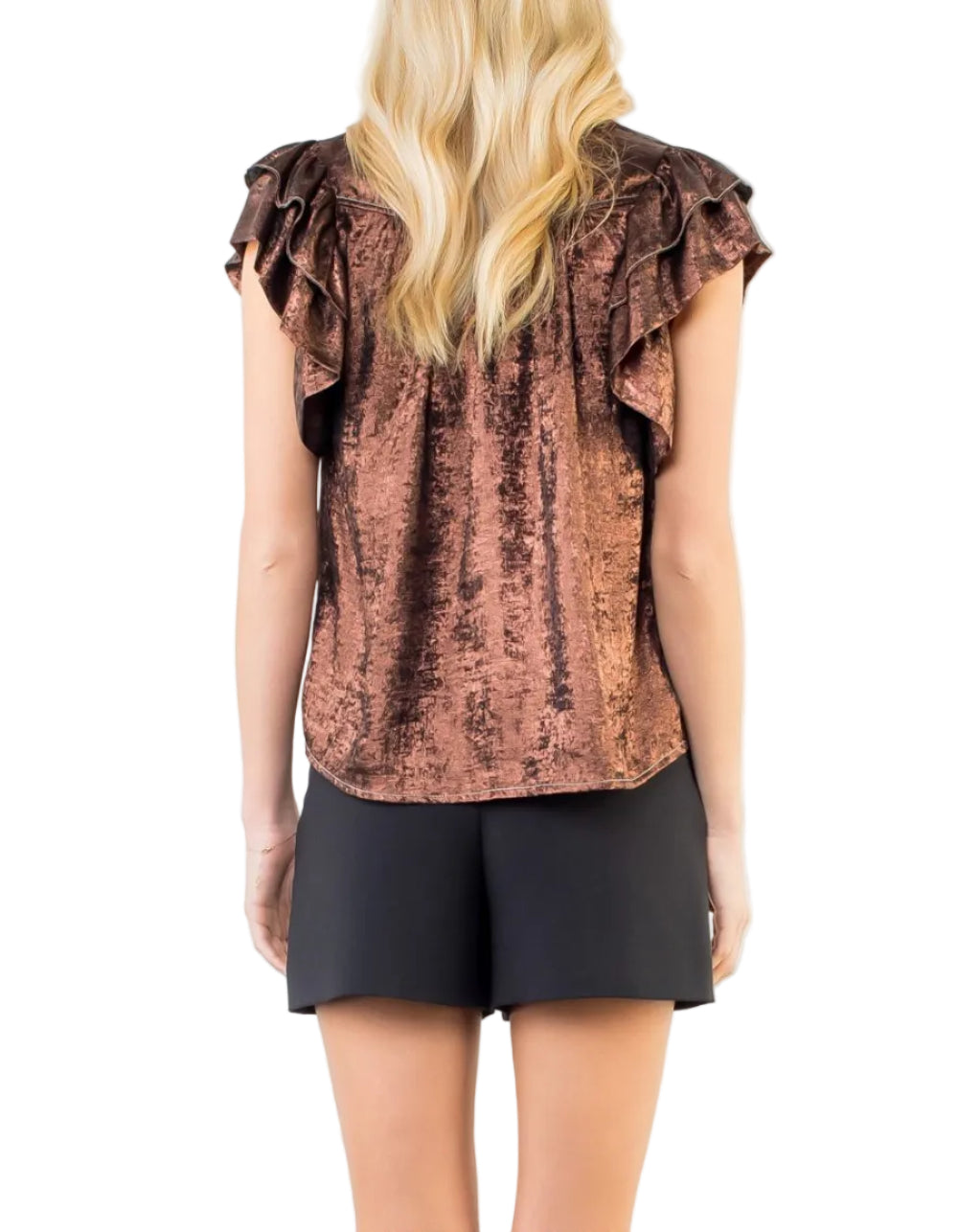 Woman wearing a brown ruffled top and black shorts on a white background